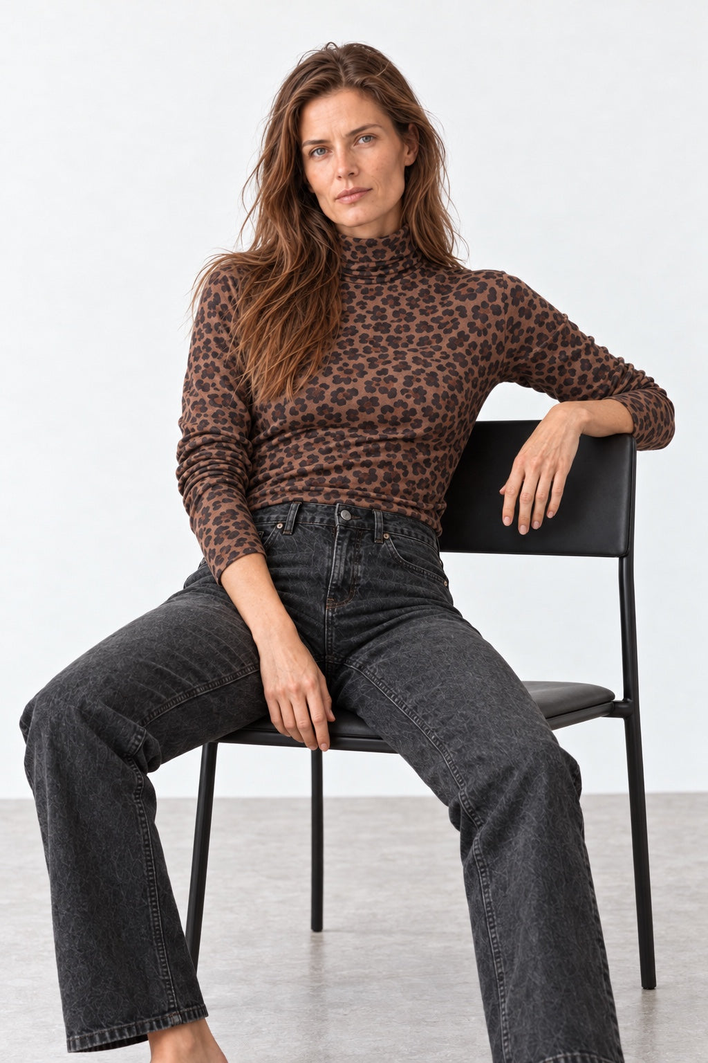Seated model wearing the Gabi brown leopard-print turtleneck